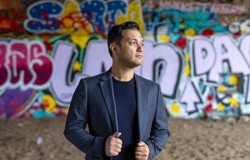 Photo of Nicholas Phan in front of graphiti wall