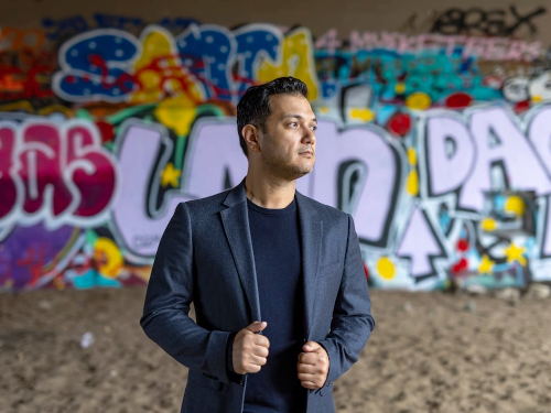 Photo of Nicholas Phan in front of graphiti wall