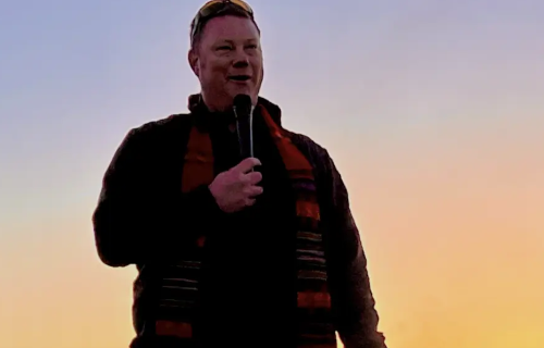 Rev Andrew Black with microphone at Caja at sunrise