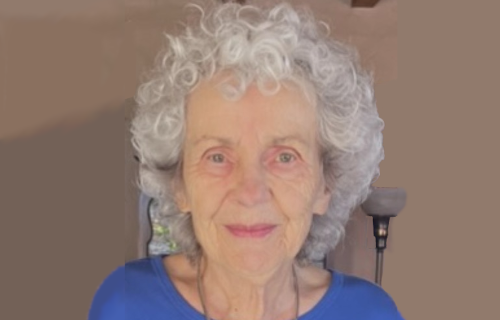 Portrait of Katherine outside an adobe house, edited to extend width
