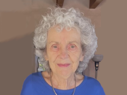 Portrait of Katherine outside an adobe house, edited to extend width