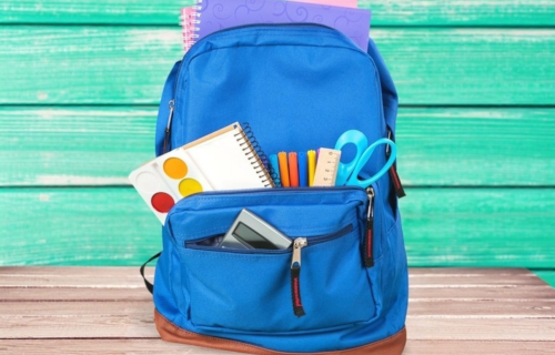 Blue backpack with school supplies showing