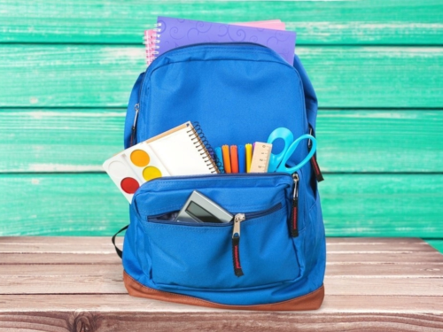 Blue backpack with school supplies showing
