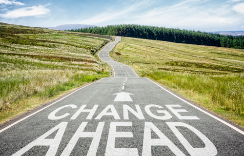 Long rural road with words "Change Ahead"