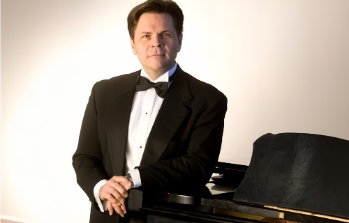 Garcia Nuthmann standing by piano