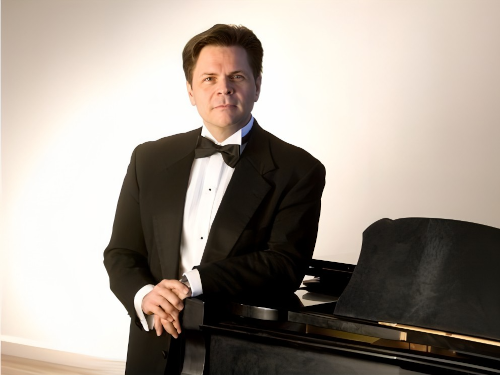 Garcia Nuthmann standing by piano