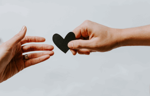 Hand giving heart to other hand News