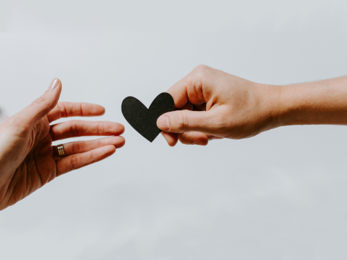 Hand giving heart to other hand News
