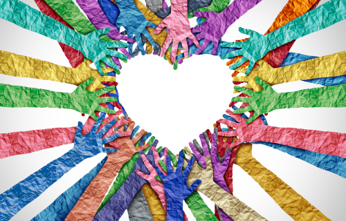 Multicolored paper hands forming a heart