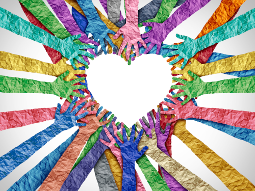 Multicolored paper hands forming a heart