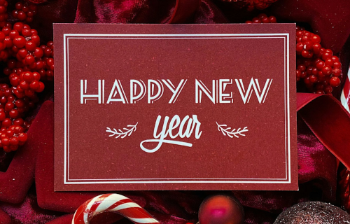 Happy New Year sign on red berries and candy canes