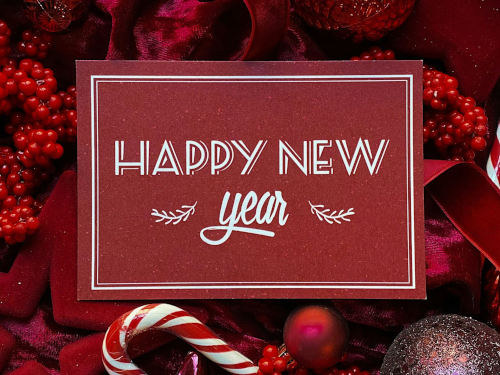 Happy New Year sign on red berries and candy canes