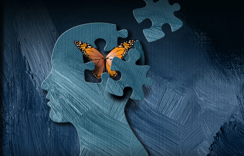 Cutout of head with butterfly and puzzle pieces