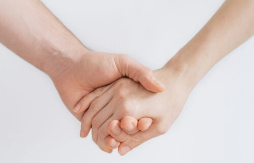 Closeup of two people holding hands