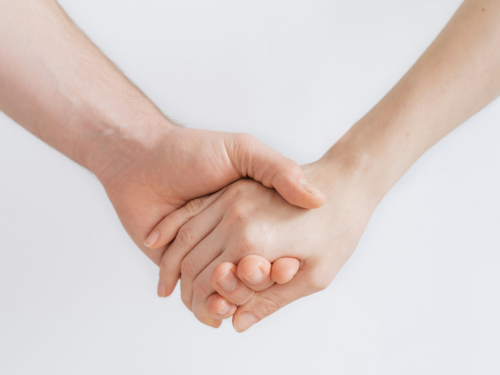 Closeup of two people holding hands