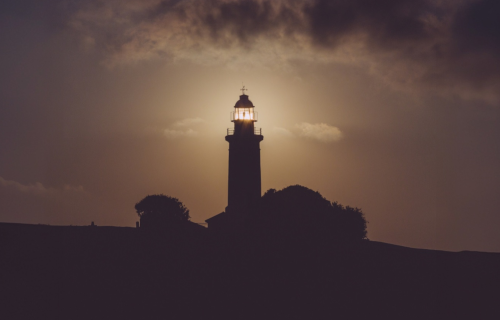 Lighthouse shining light in early evening