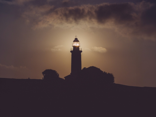 Lighthouse shining light in early evening