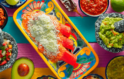 Red enchilladas and assorted Mexican side dishes