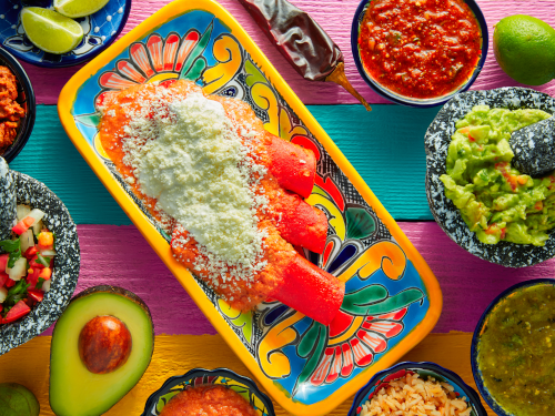 Red enchilladas and assorted Mexican side dishes