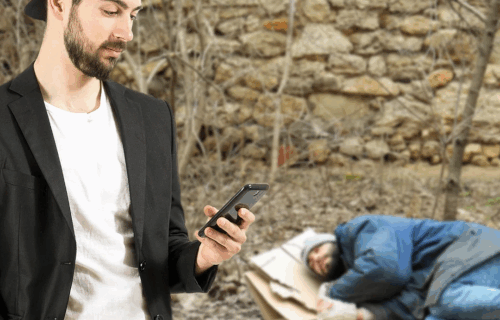 Man standing next to homeless man on the ground sleeping