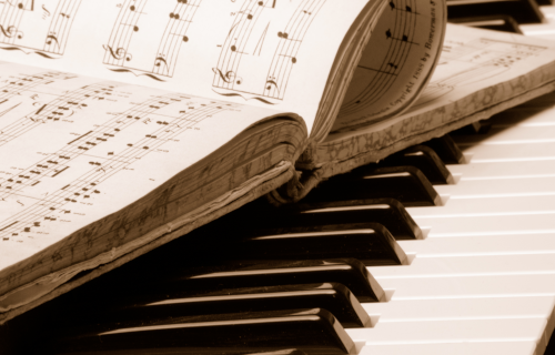 Close up of book of music on top of piano keys