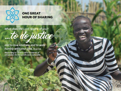 African woman smiling and holding a leaf