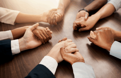 Hands being held around a table