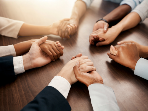 Hands being held around a table