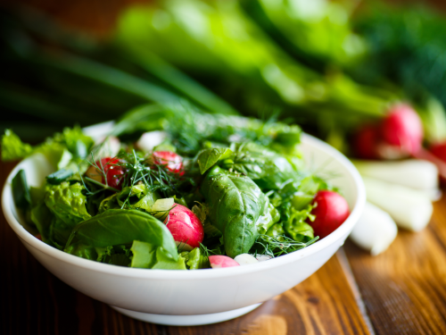 Salad bowl filled with greens and vegetables