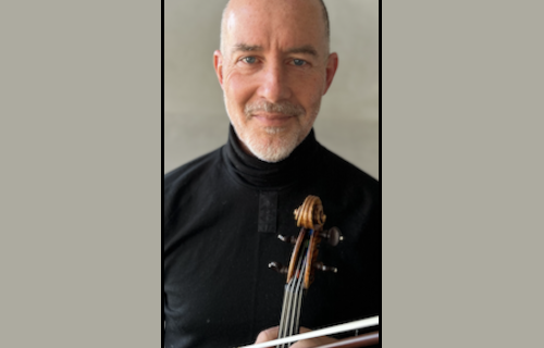Stephen Redfield in a black shirt holding a violin