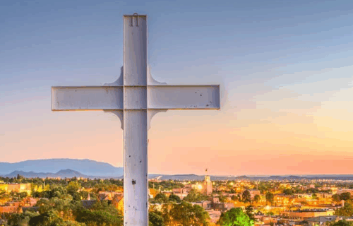 Image of cross in foreground and Santa Fe in background