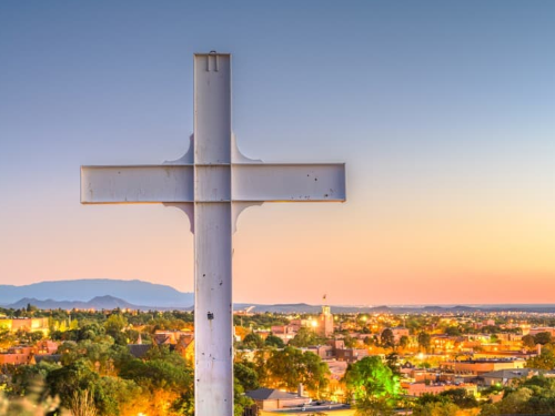 Image of cross in foreground and Santa Fe in background