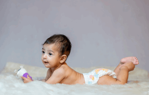 Baby lying on tummy in a diaper