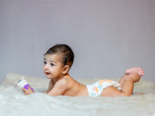 Baby lying on tummy in a diaper