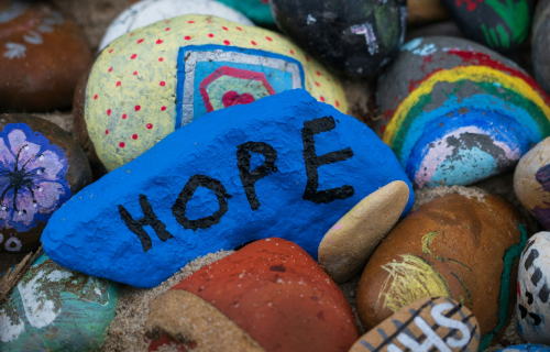 Colorfully painted rocks with one labeled HOPE