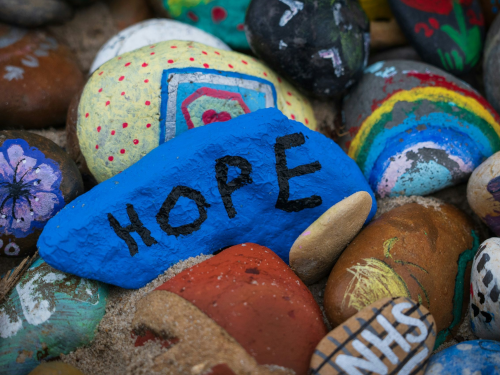 Colorfully painted rocks with one labeled HOPE