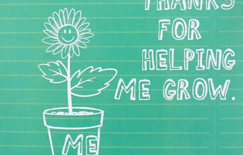 Image of a calk boar with text in chalk: "Thanks for help me grow" next to a chalk drawing of a flower growing from a flower pot. The flower has a smiling face.